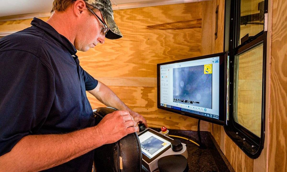 Techniker wertet die Aufnahme einer Kanalkamera am Monitor aus