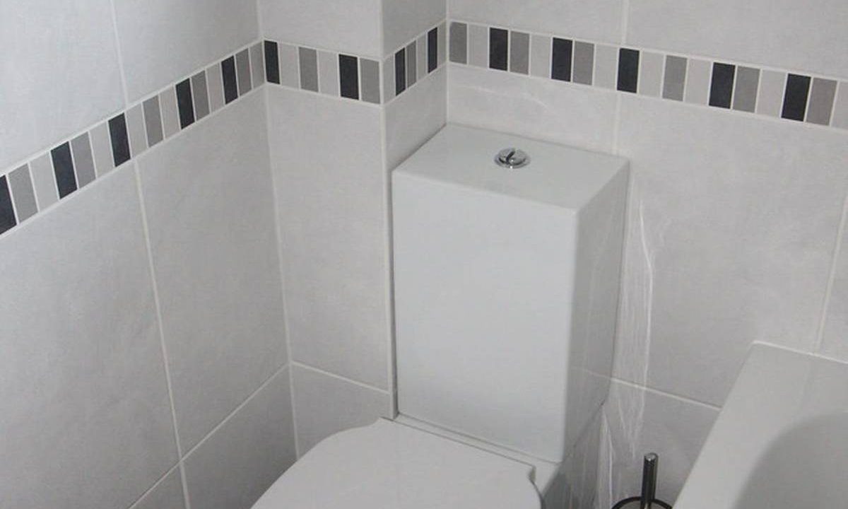 Moderne weiße Toilette in einem gefliesten Badezimmer