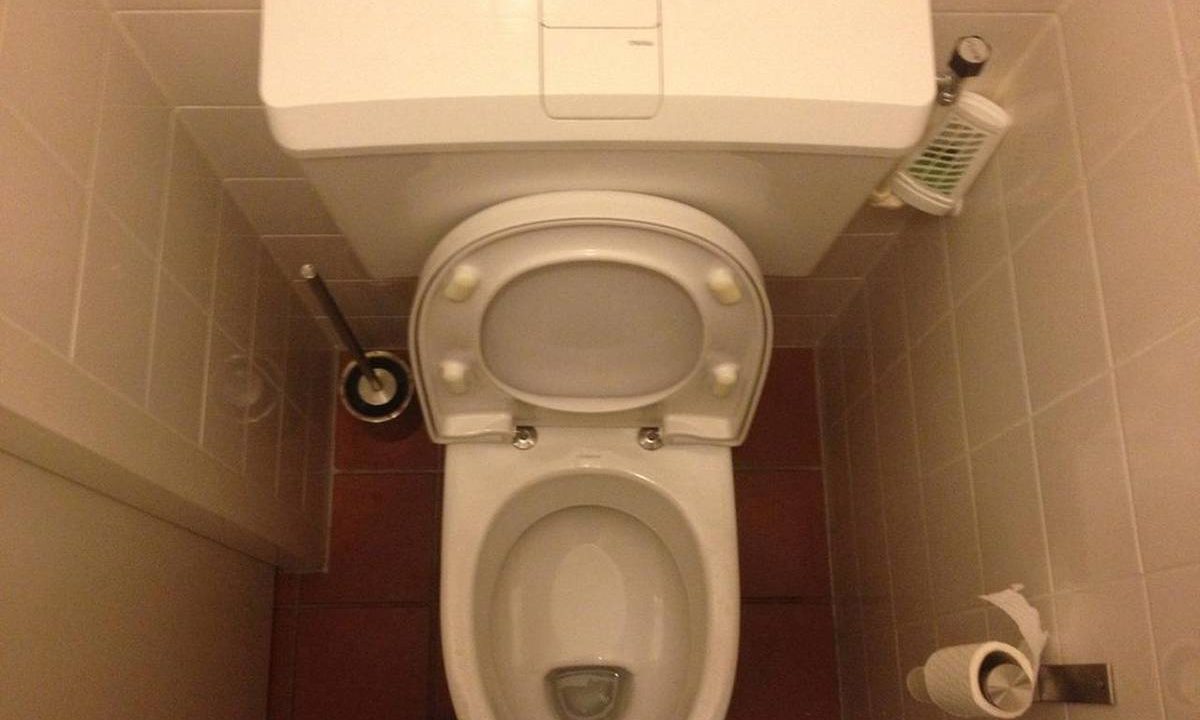 Toilette in einem kleinen gefliesten Bad